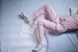A person’s legs moving restlessly while they’re in bed.