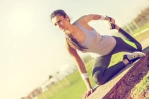 Female athlete stretching after her workout to prevent vein disease in her legs