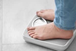 Woman checking her weight for vein health in geneva, IL