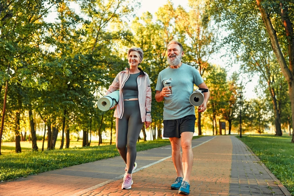 Senior couple goes for a walk in a city park.